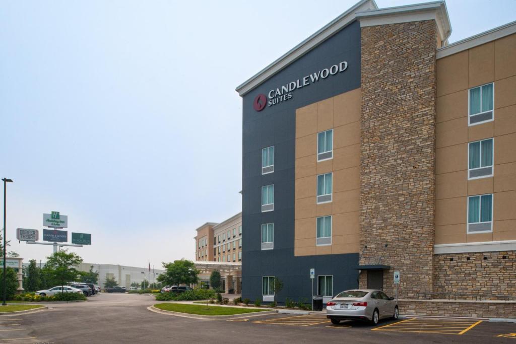 乔利埃特Candlewood Suites - Joliet Southwest, an IHG Hotel的停车场内有停车位的建筑物