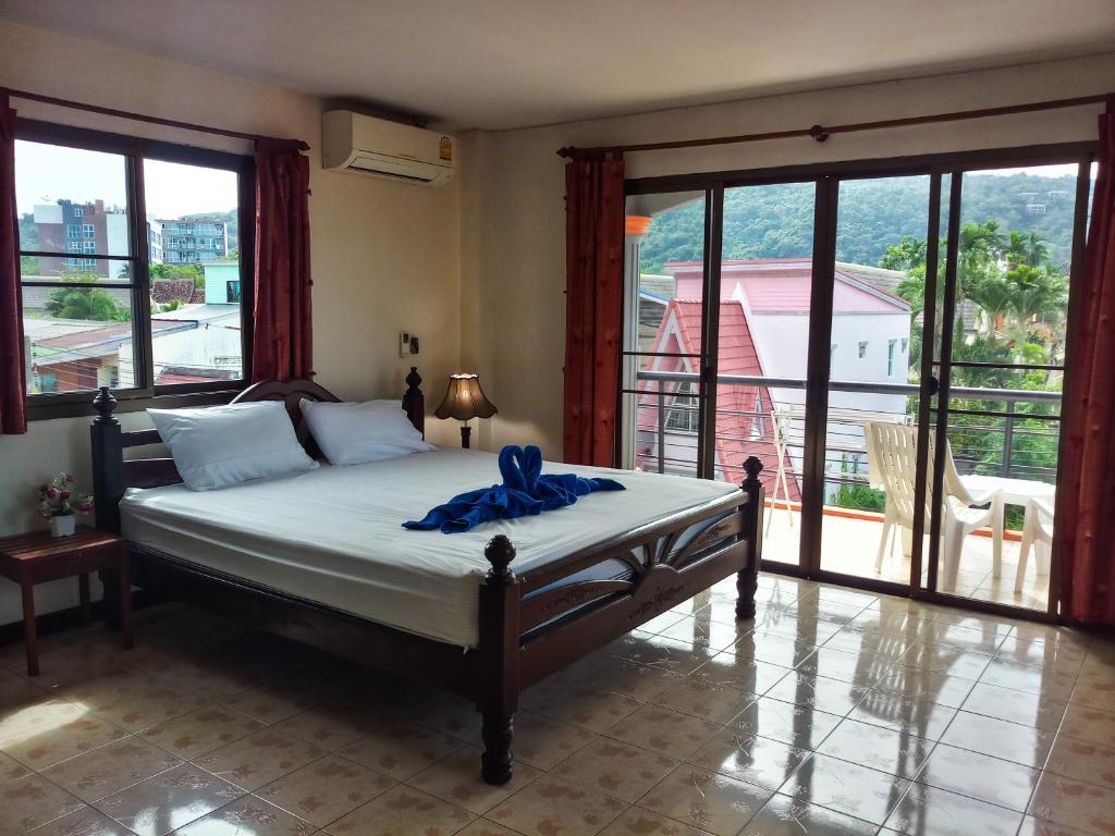 卡塔海滩Kata Lina guesthouse的一间卧室配有一张带蓝色丝带的床