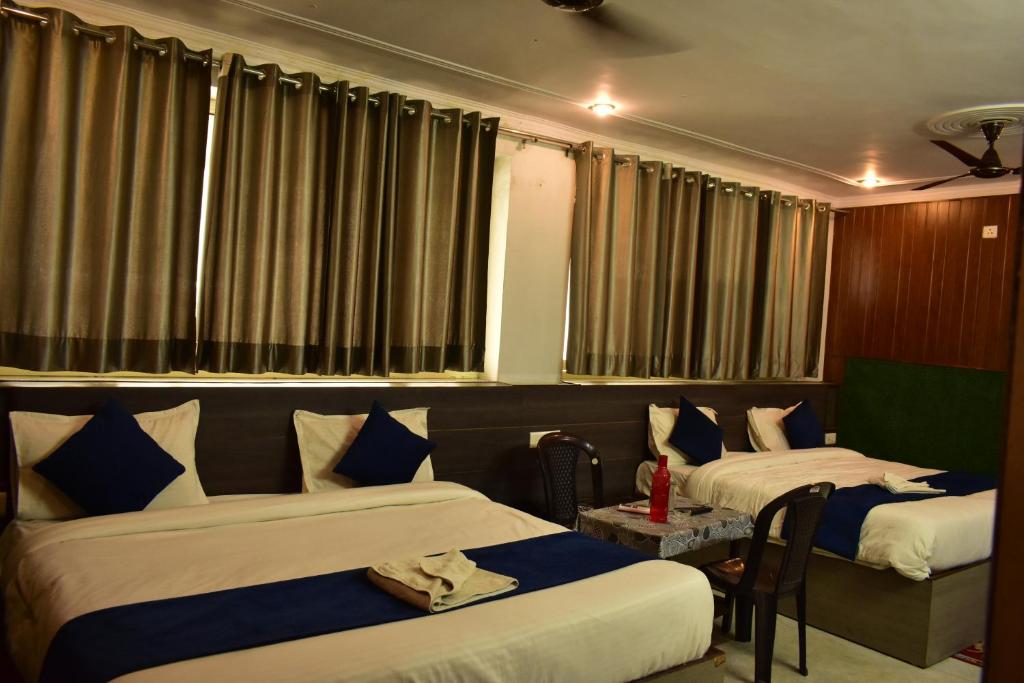 瑞诗凯诗Namastexplorer Rishikesh的酒店客房设有两张床和一张桌子。