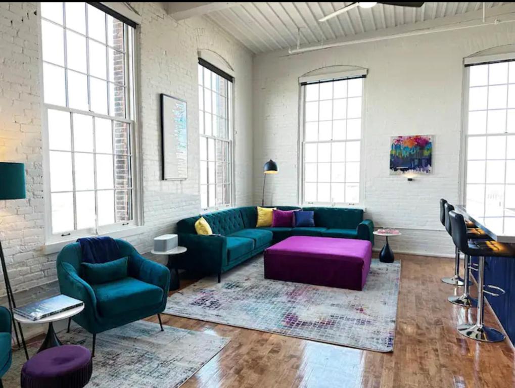 尤蒂卡Penthouse: Casa Colore的客厅配有绿色沙发和紫色家具
