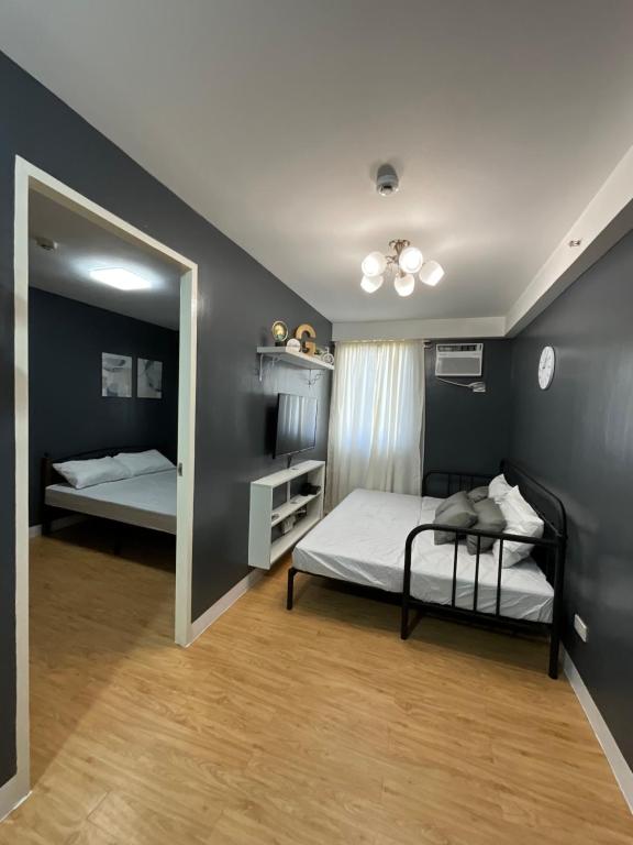 达沃市Condo Rentals in Arezzo - 1 Br Condo的一间卧室配有两张床和镜子