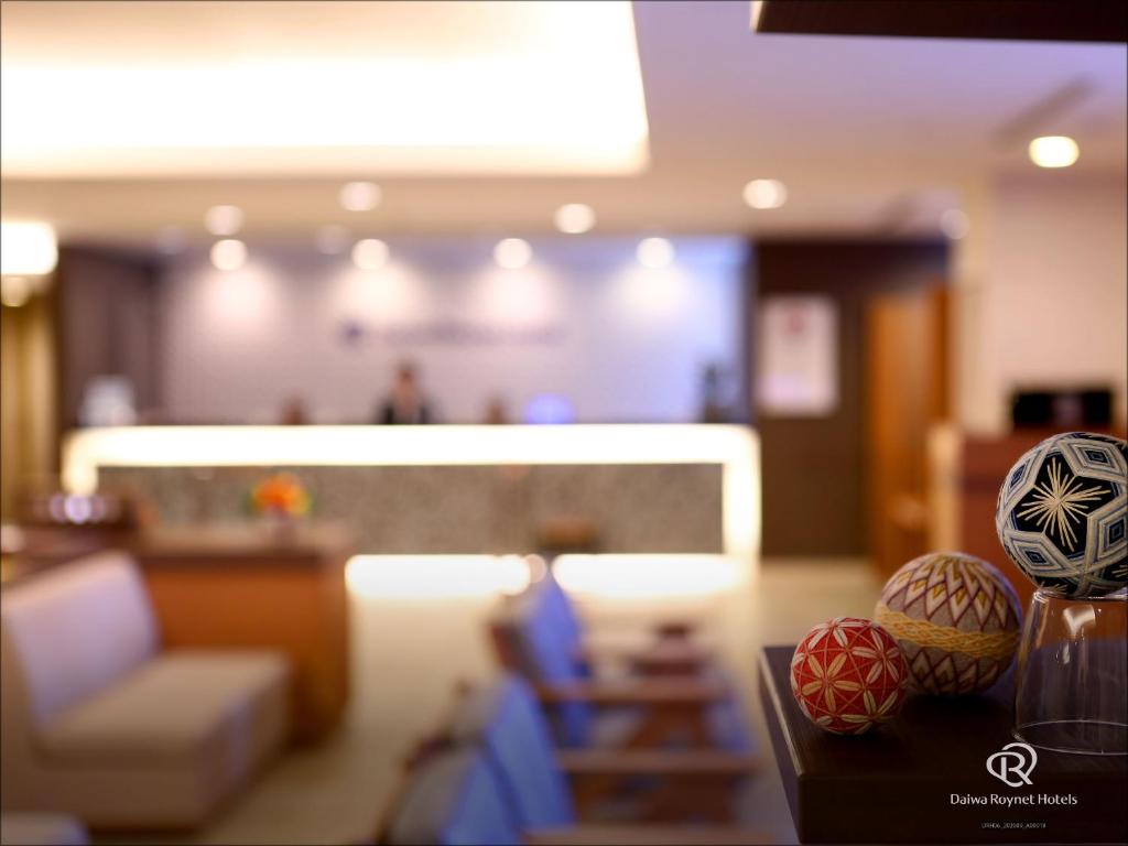 高松高松大和鲁内酒店的客厅配有沙发和桌上的球