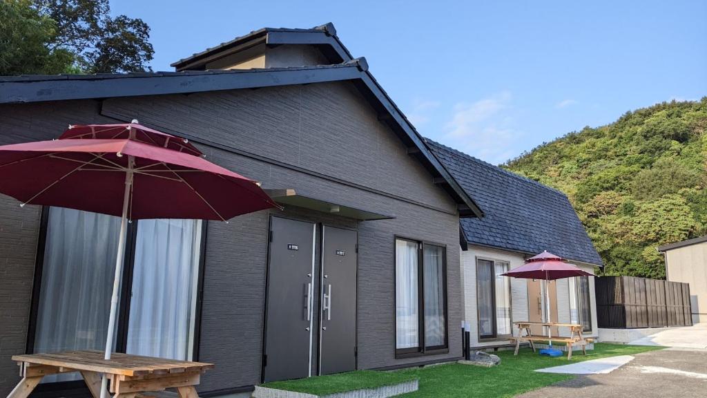 和歌山関空国際ホテル的一个带野餐桌和雨伞的房子