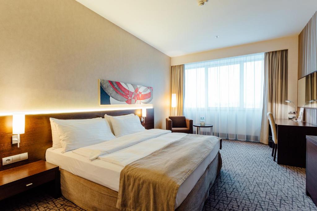 日利纳吉利纳假日酒店的酒店客房设有一张大床和一张书桌。