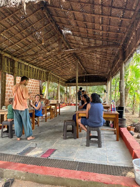 戈卡尔纳HostelExp, Gokarna - A Slow-Paced Backpackers Community的一群坐在餐厅桌子上的人