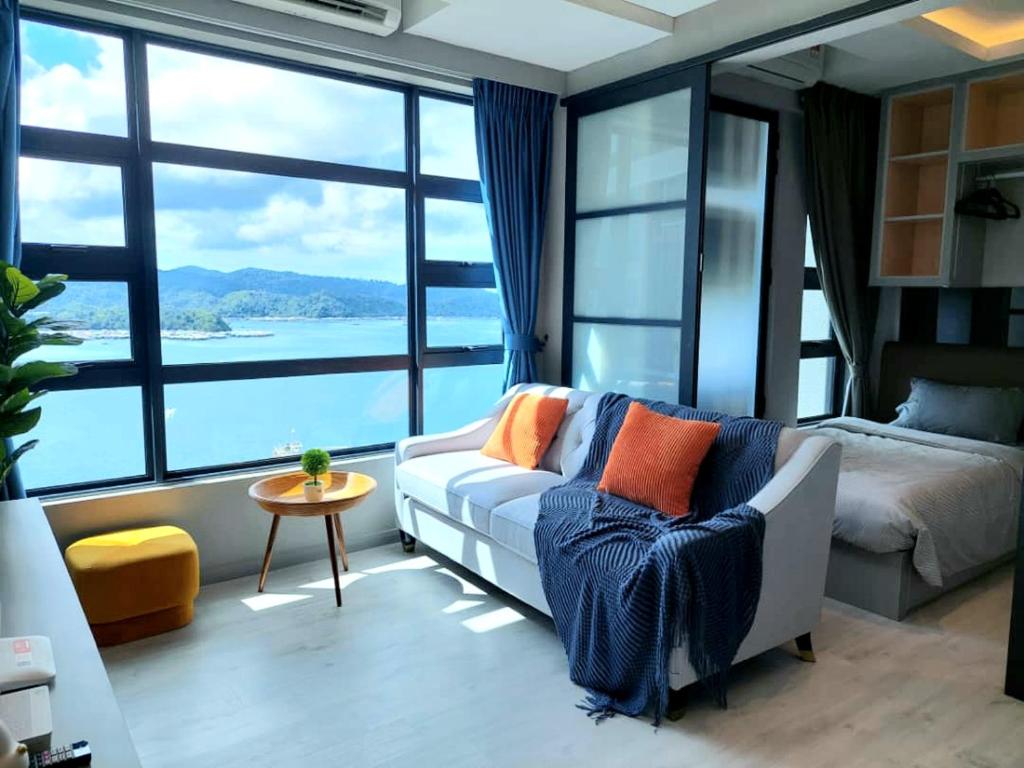 哥打京那巴鲁J'Stay Seaview Suite Jesselton Quay Kota Kinabalu的带沙发和床的客厅以及大窗户。