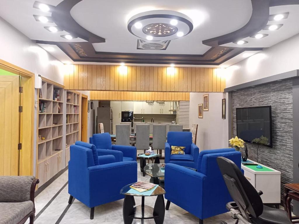 卡拉奇White Lotus Karachi的客厅配有蓝色椅子和电视