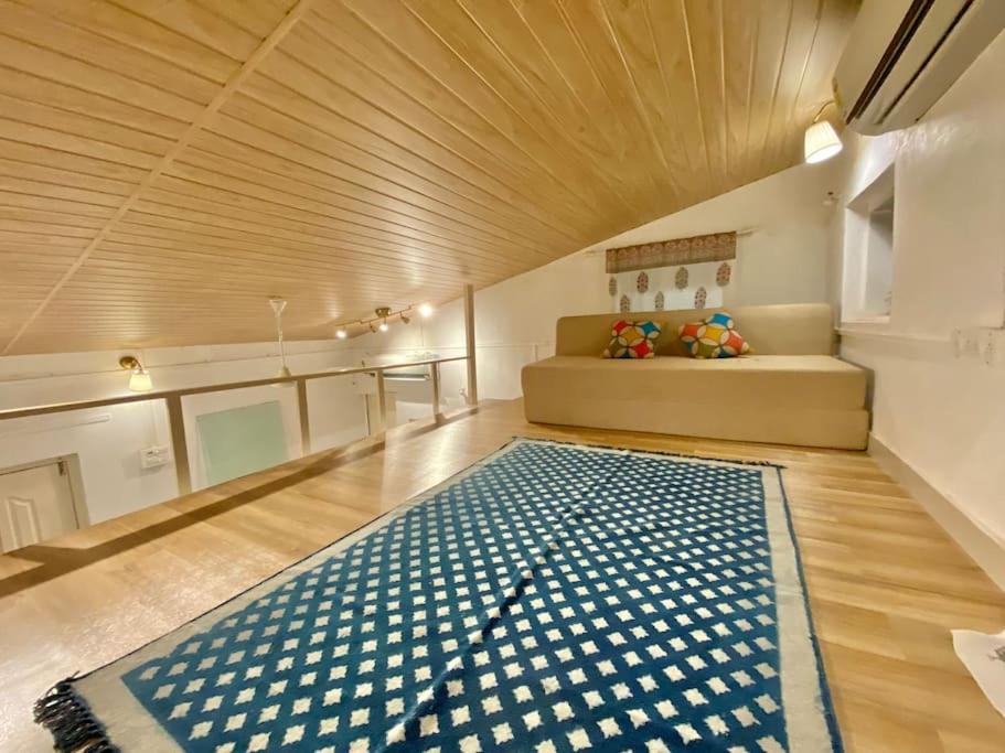 孟买Bandra Cottage (With Yard)的一间配有沙发的房间和地板上的地毯