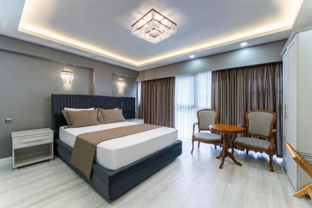 伊斯坦布尔Classio Hotel Kadıköy的卧室配有一张床和一张桌子及椅子