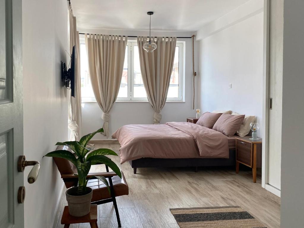 利马索尔Loft with a cosy terasse的一间卧室配有一张床和盆栽植物
