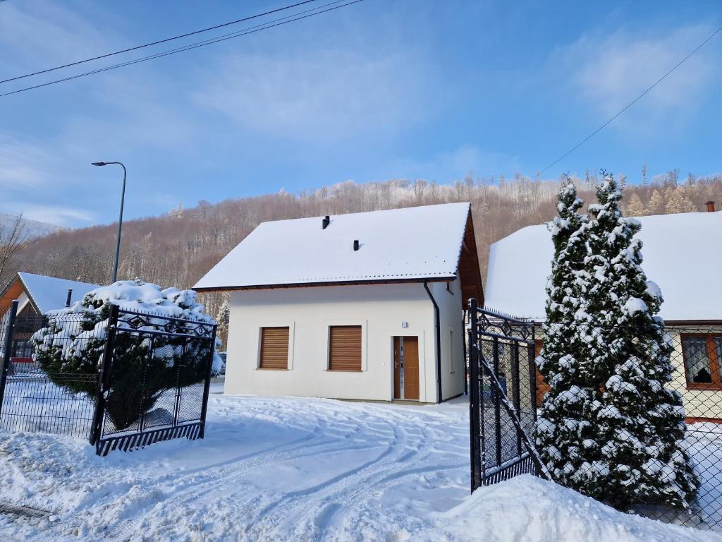 BystraDomek Pod Klimczokiem的雪中带门的房子