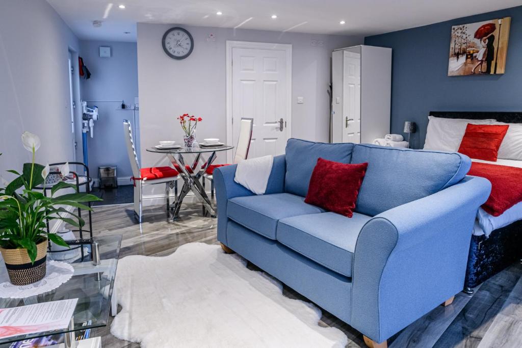 WillenhallLuxury one bedroom guesthouse M6, Junction 10 Walsall的客厅配有蓝色沙发,设有床