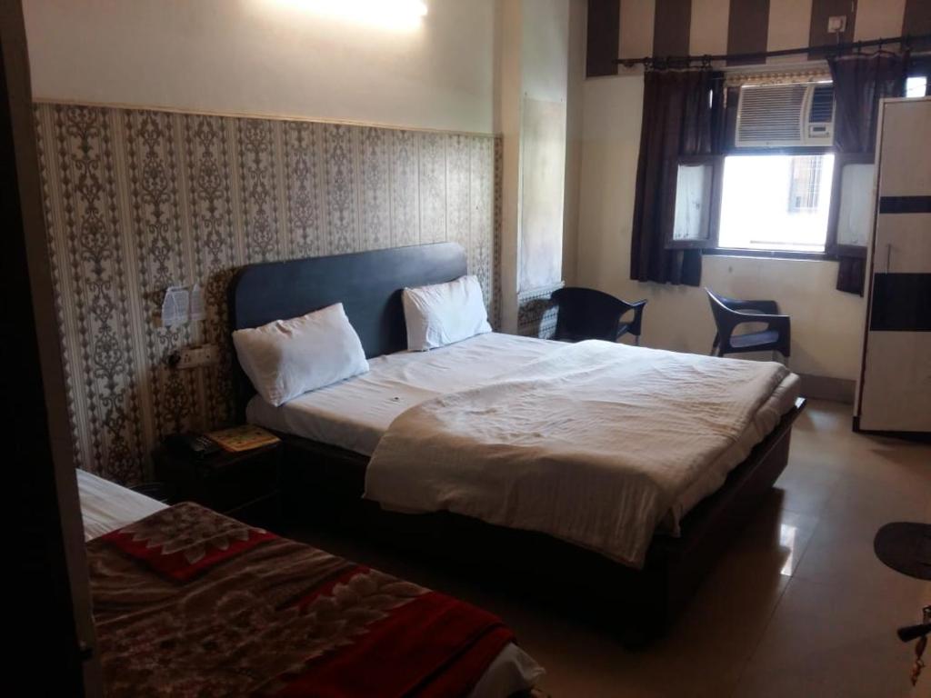 哈里瓦Hotel Shiva Palace haridwar nearby bus and railway station的酒店客房设有两张床和窗户。