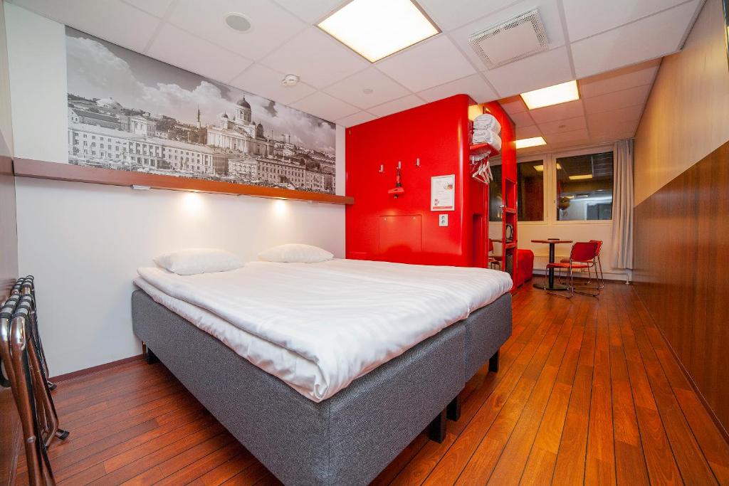 赫尔辛基赫尔辛基市中心奥梅那酒店的一间卧室设有一张红色墙壁的大床