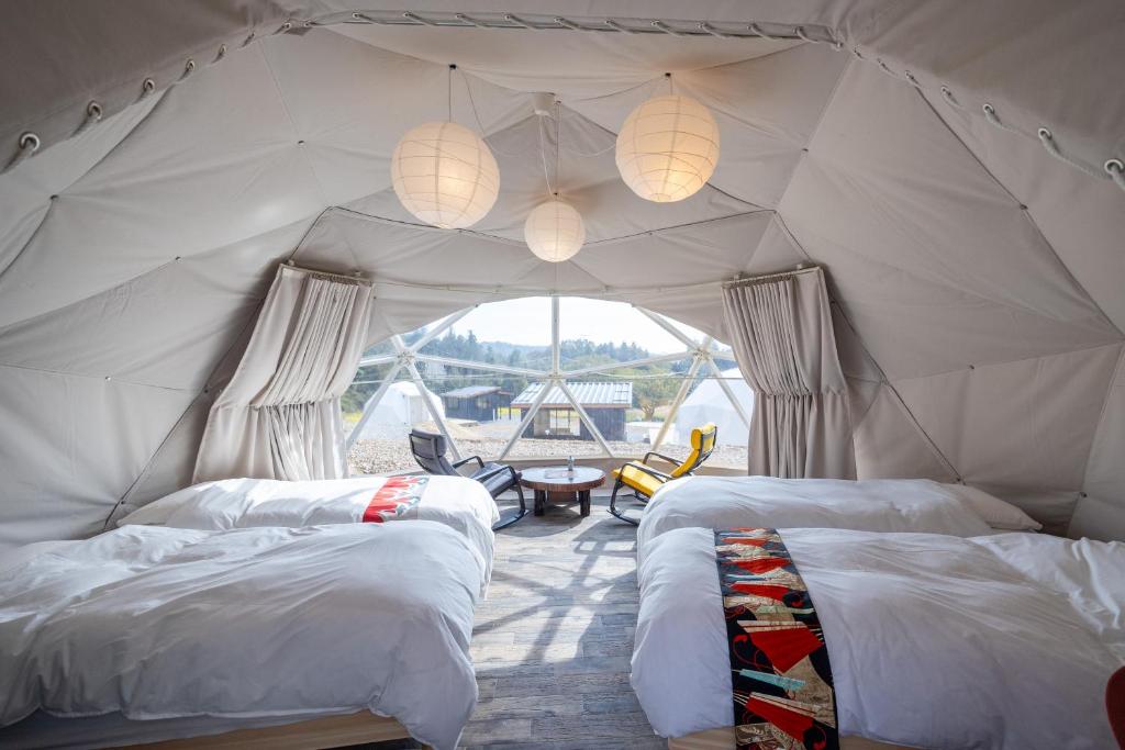 Mizunami里山グランピングむすびペット棟的帐篷内带两张床的房间