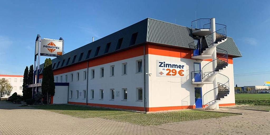 施科伊迪茨PRIMOTEL的白色和橙色的建筑,上面有标志