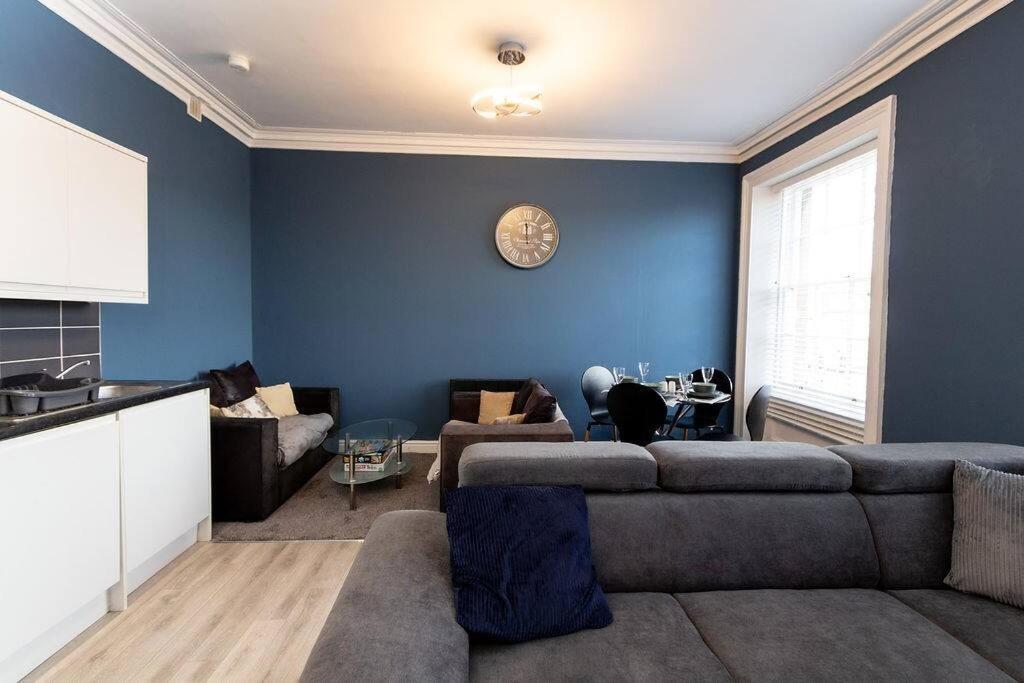 伯肯黑德Lavish 2Bed Apartment in the Heart of Birkenhead的带沙发和蓝色墙壁的客厅