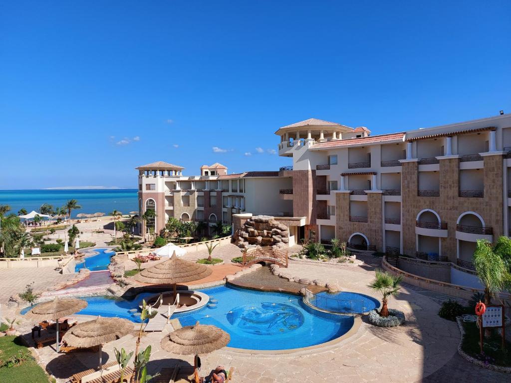赫尔格达Royal Beach Private Apartments Hurghada的享有带游泳池和遮阳伞的度假村景色