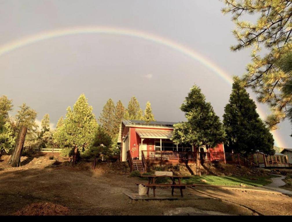 North ForkRed Barn Retreat的一个带野餐桌的房子上方的彩虹