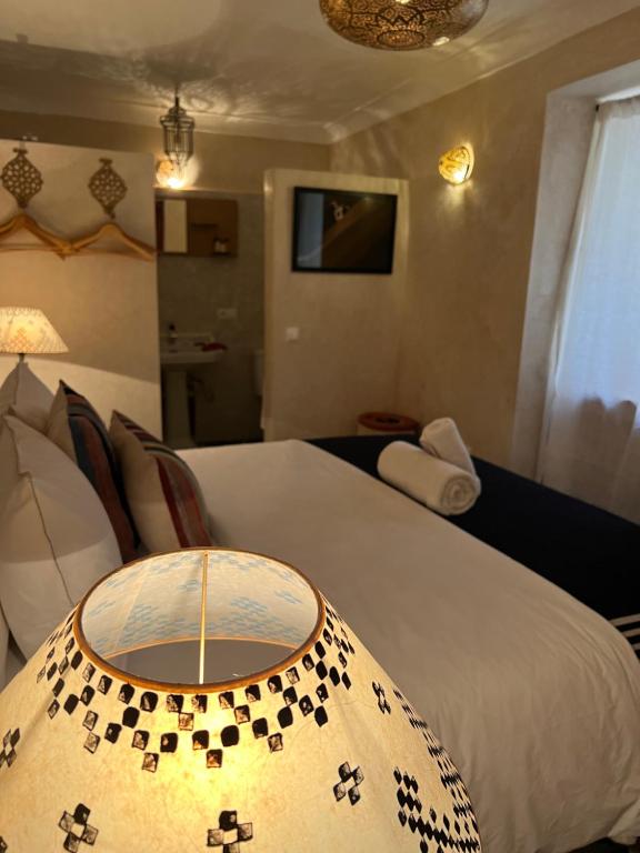 马拉喀什Riad Alena的酒店客房配有一张床铺和一张桌子。