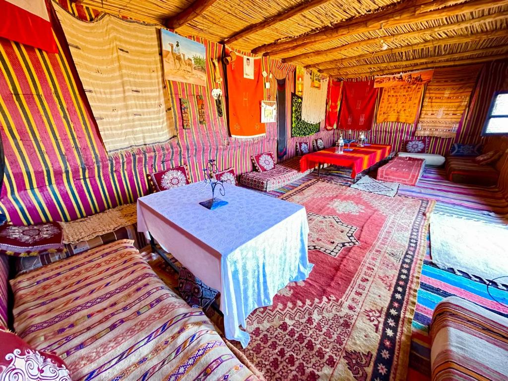 MhamidMhamid Sahara Golden Dunes Camp - Chant Du Sable的一间客房内配有桌椅的房间