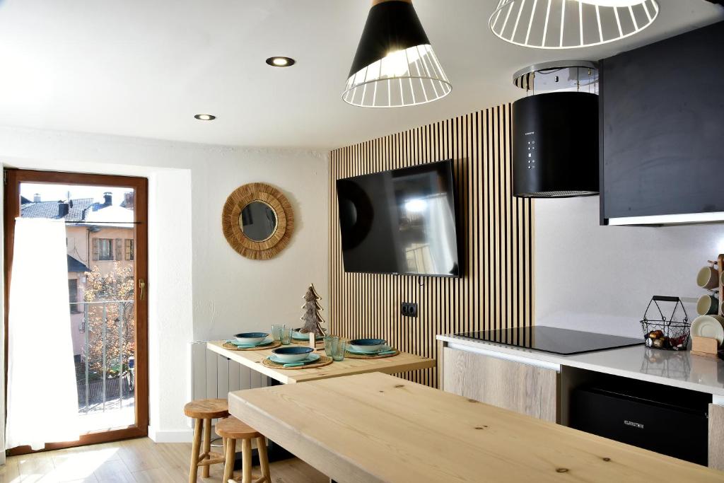 普奇塞达LA CASETA DELS HEROIS的厨房配有木桌和墙上的电视。