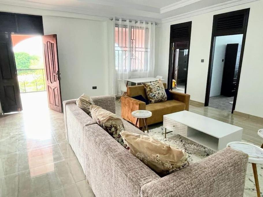 库马西Bright & Beautiful 2-Bed Apartment, Central Kumasi的客厅配有两张沙发和一张桌子