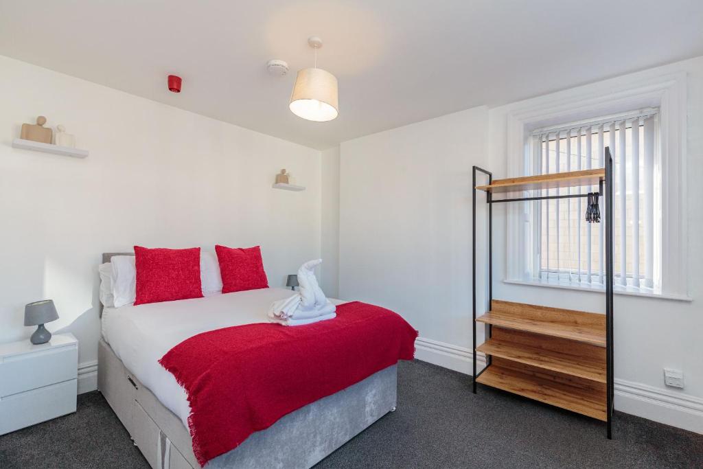 布莱克浦Cherry Property - Cranberry Suite的一间卧室配有红色枕头的床