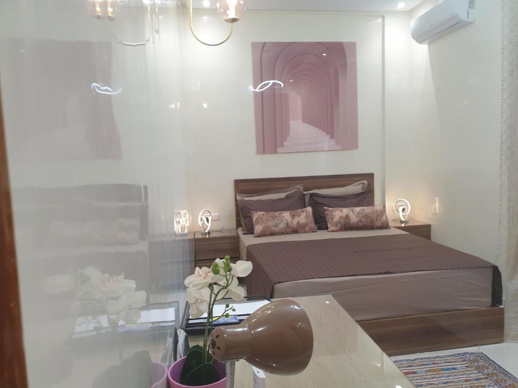 马拉喀什Bel appartement moderne au cœur de guelize的一间卧室配有一张床和一张鲜花桌