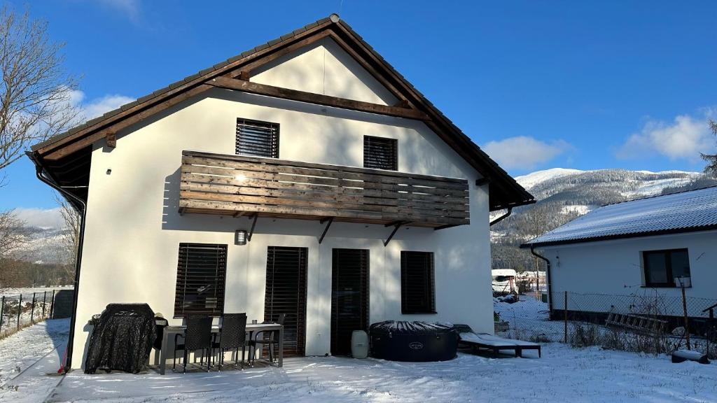 日亚尔Apartmánový dom Žiar s vírivkou a saunou的雪中一座白色的古老房子,有山