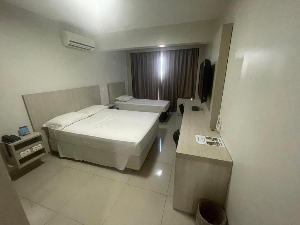 巴西利亚MIX APART Hotel的酒店客房,配有床和电视