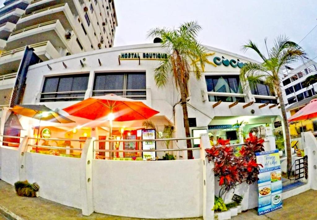 萨利纳斯Hotel Cocos的大楼前带遮阳伞的餐厅