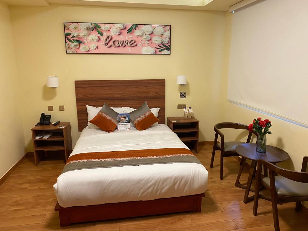 利马SM HOTEL Plus的一间卧室配有一张床和一张花瓶桌子