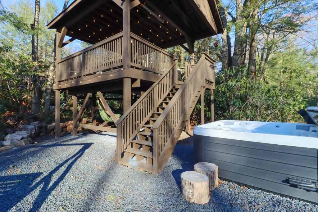 坦纳斯维尔Creekside Tannersville Cabin 2 Acres and Hot Tub!的木制凉亭设有浴缸旁的楼梯