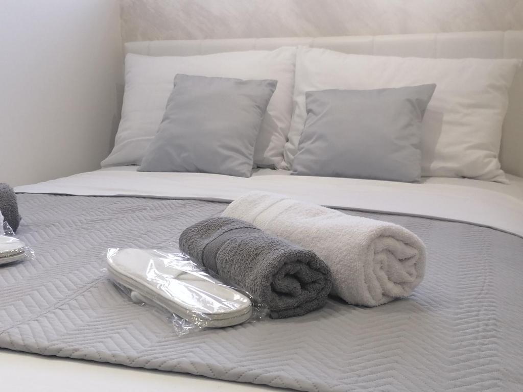 博尔DIV Bor的一张带毛巾的床和一部电话