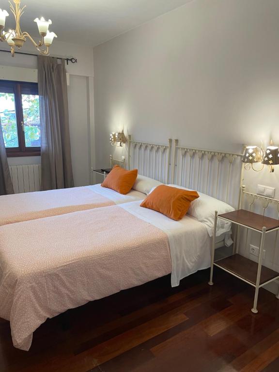 CiérvanaHotel Kaia的一间卧室配有一张大床和两个橙色枕头