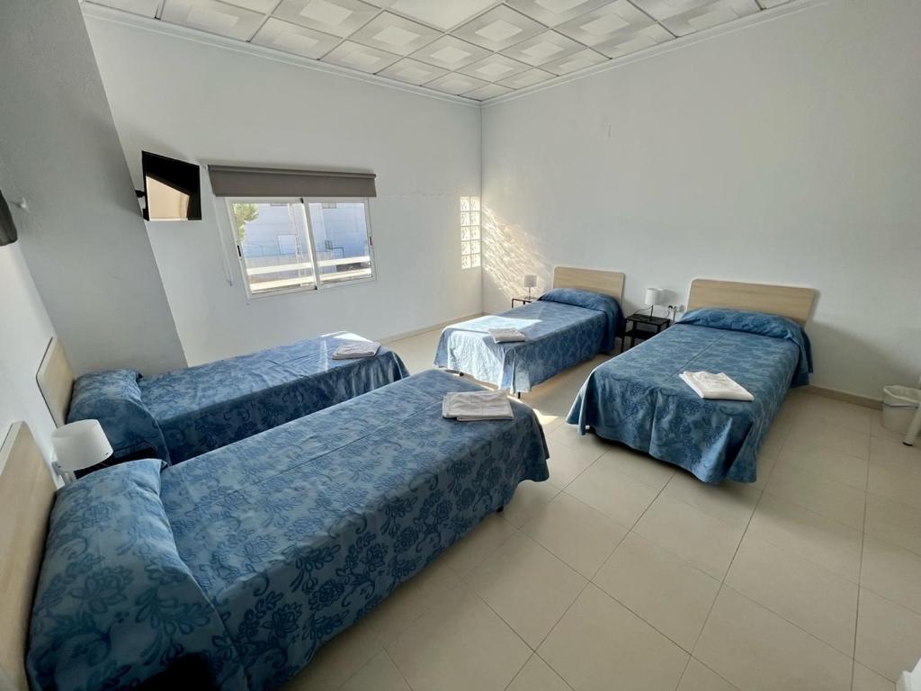 拉努西亚Hostal Kaizen的一间设有三张床的房间,其中一张沙发
