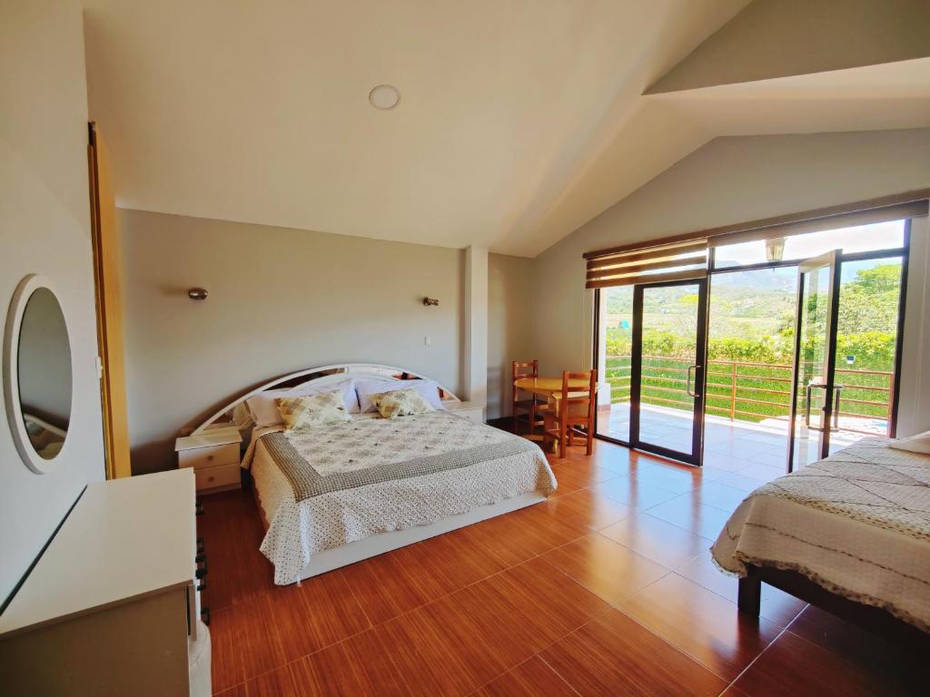 洛哈Quinta Esperanza的一间卧室设有一张床和一个滑动玻璃门