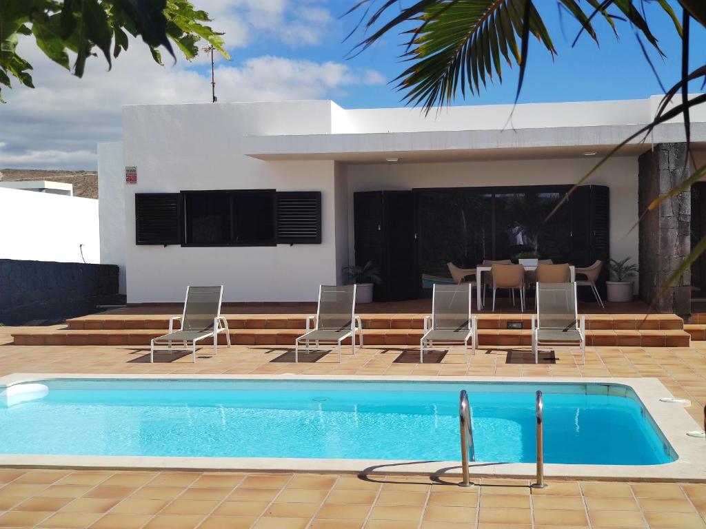 蒂亚斯Casa Airalba的一个带椅子的游泳池以及一座房子
