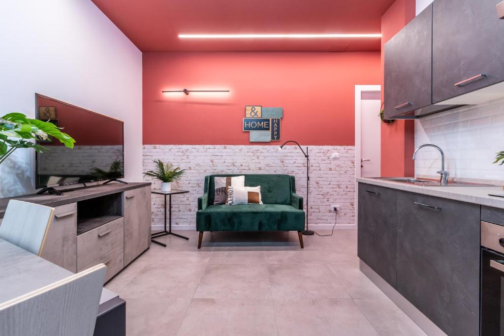博洛尼亚Tartini Lofts的厨房设有红色的墙壁和绿色的椅子