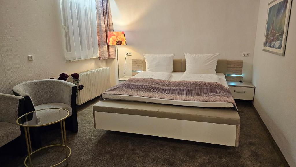 鲁尔河畔米尔海姆科隆霍夫酒店的一间卧室配有一张大床和一把椅子
