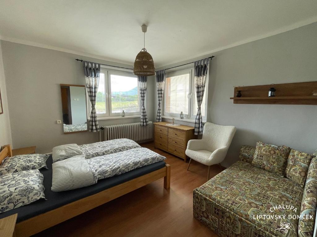 利普托斯基米库拉斯Chalupa Liptovský domček的一间卧室配有一张床、一张沙发和一把椅子