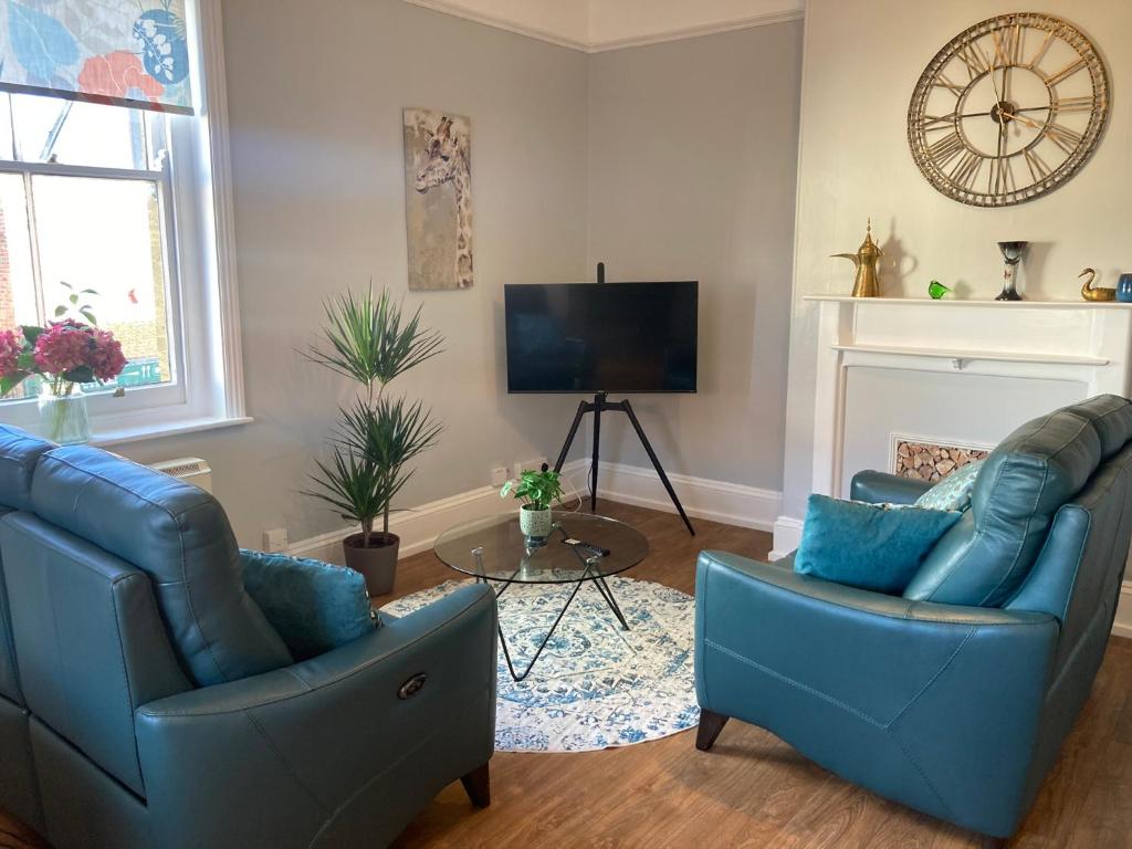 约维尔Stylish Flat in Yeovil Somerset的客厅配有2把蓝色椅子和电视