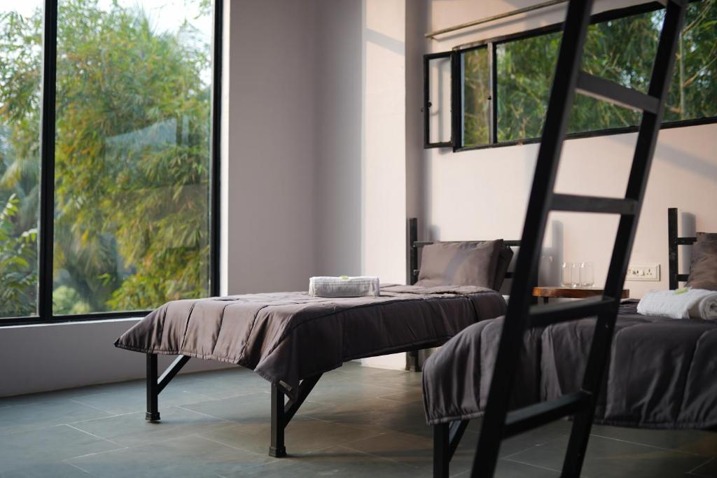 NavadwīpSoultoSoul Guesthouse的客房设有两张床和一张窗户椅子。