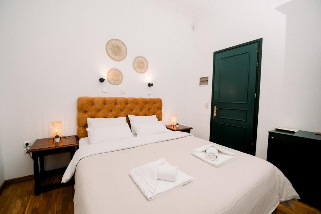 卡拉马塔Ntouana hotel的卧室配有白色大床和白色枕头