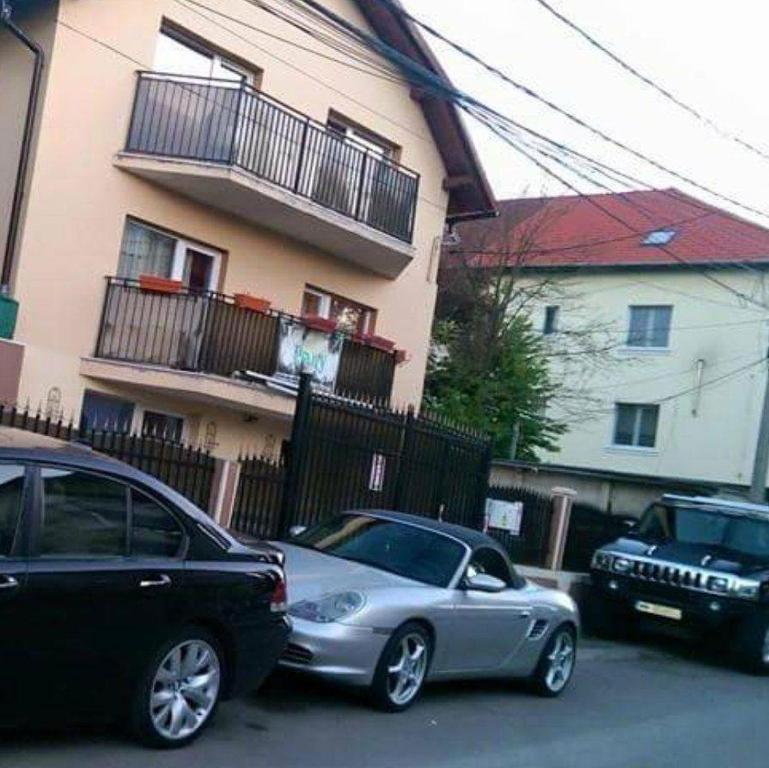 克卢日-纳波卡Casa Thomas Cluj的两辆汽车停在大楼前的停车场