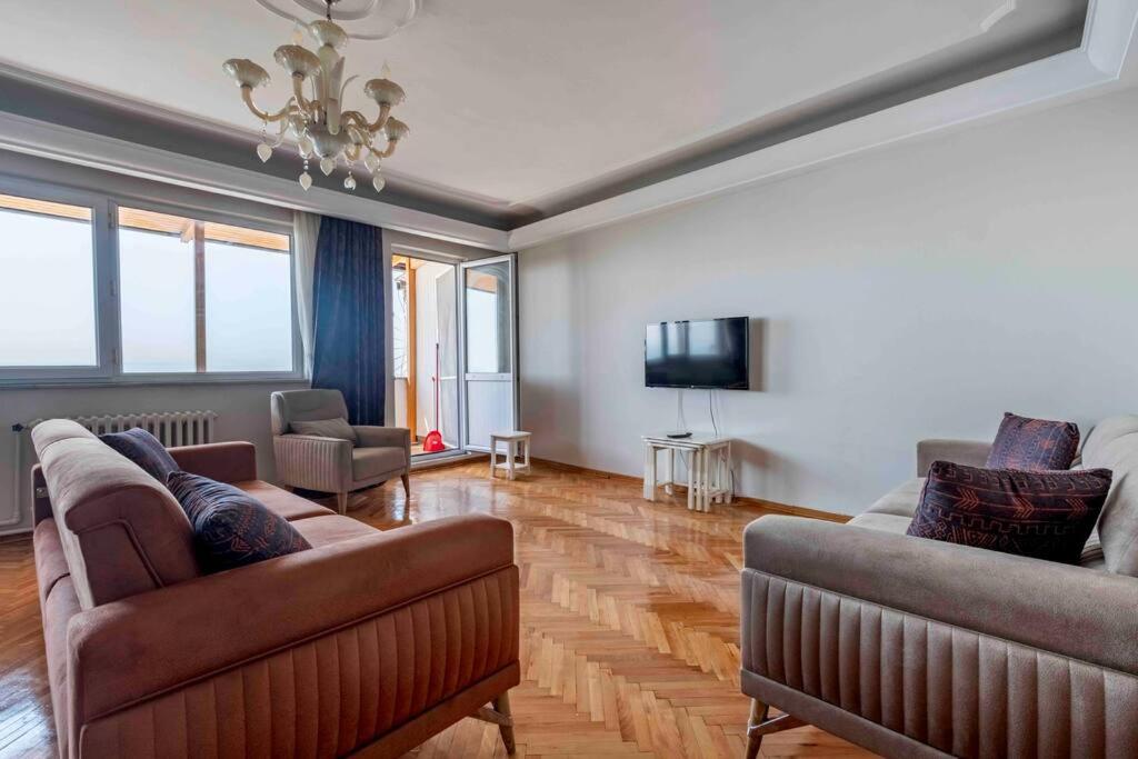 伊斯坦布尔Bakirkoyde essiz harika konumda的客厅配有2张沙发和1台平面电视
