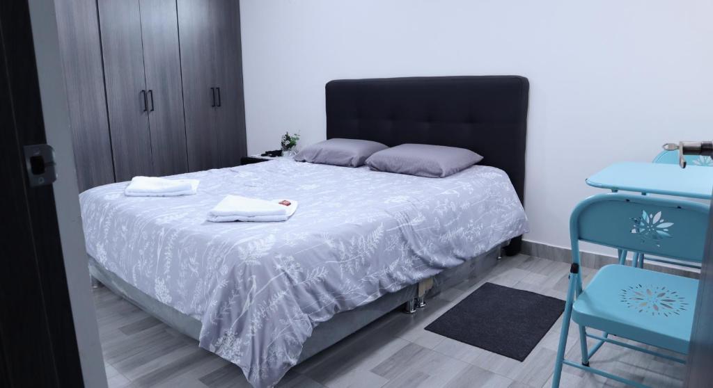 TocancipáTOCANCIPÁ, Increíble, Hermoso y Moderno APARTAMENTO COMPLETO!的一间卧室配有一张床,上面有两条毛巾