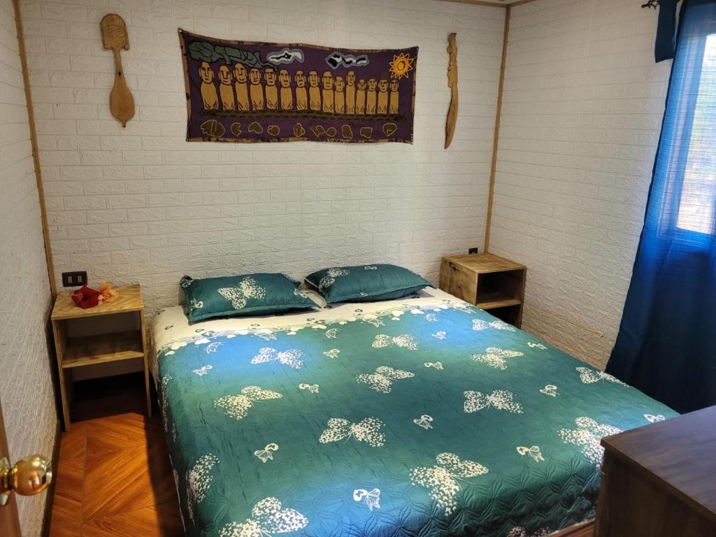 安加罗阿Cabaña tongarikii的一间卧室配有一张带蓝色棉被和枕头的床