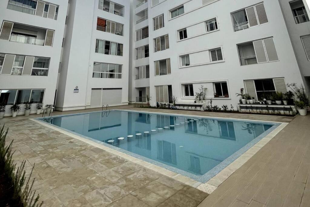 穆罕默迪耶Appartement avec piscine - Mohammadia的大楼前的游泳池